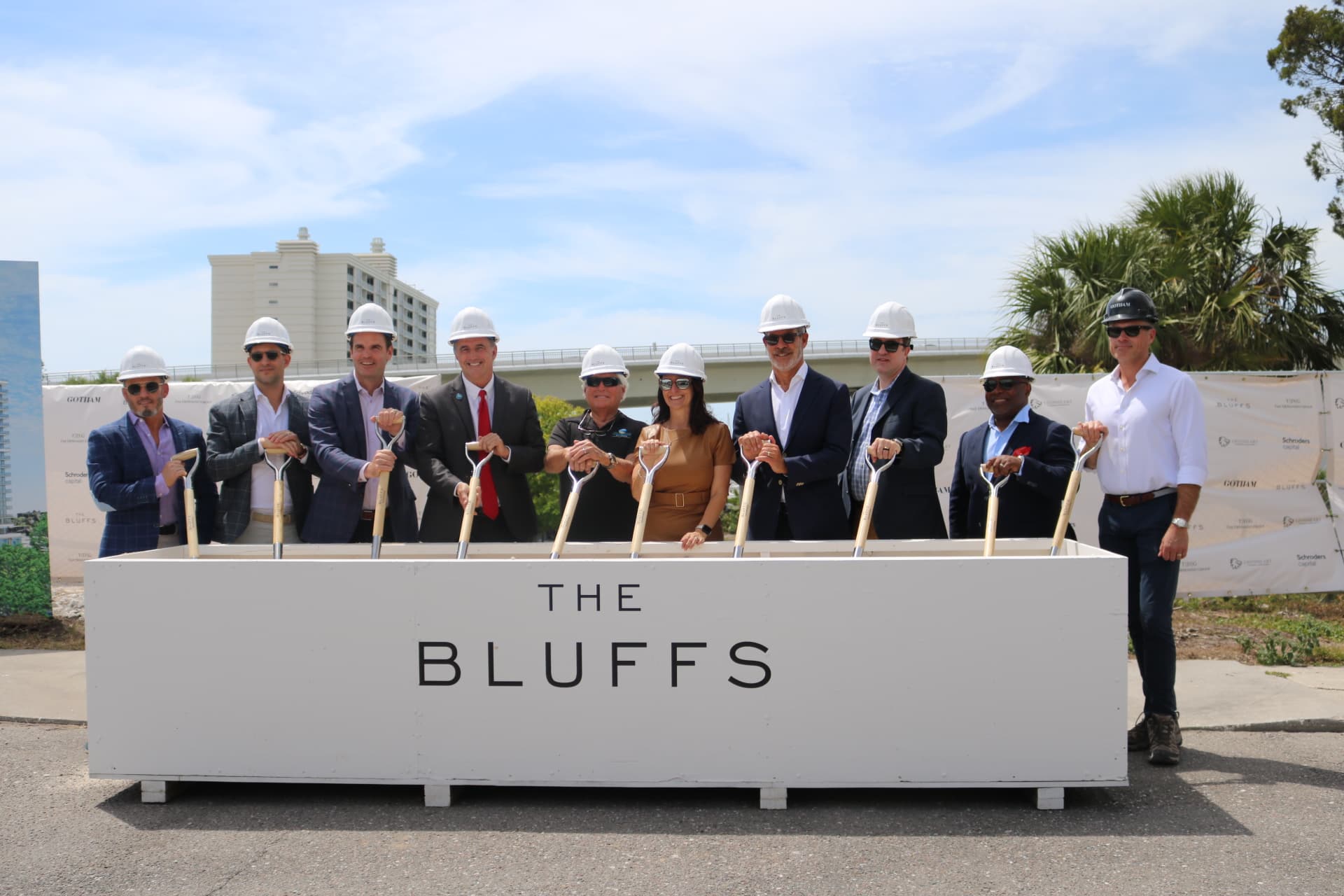 9 men and one female holding shovels