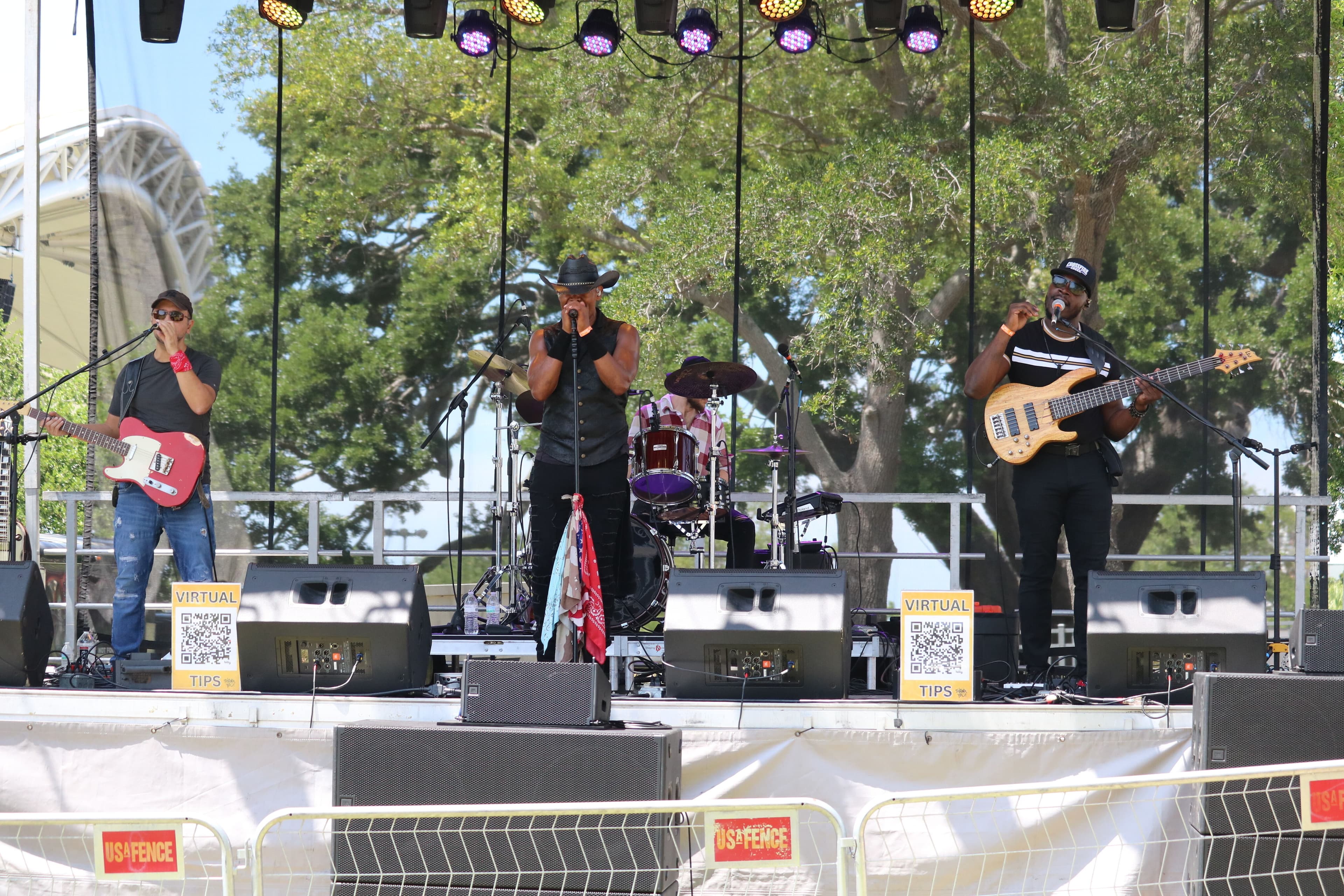 Three man singing on a stage with guitars