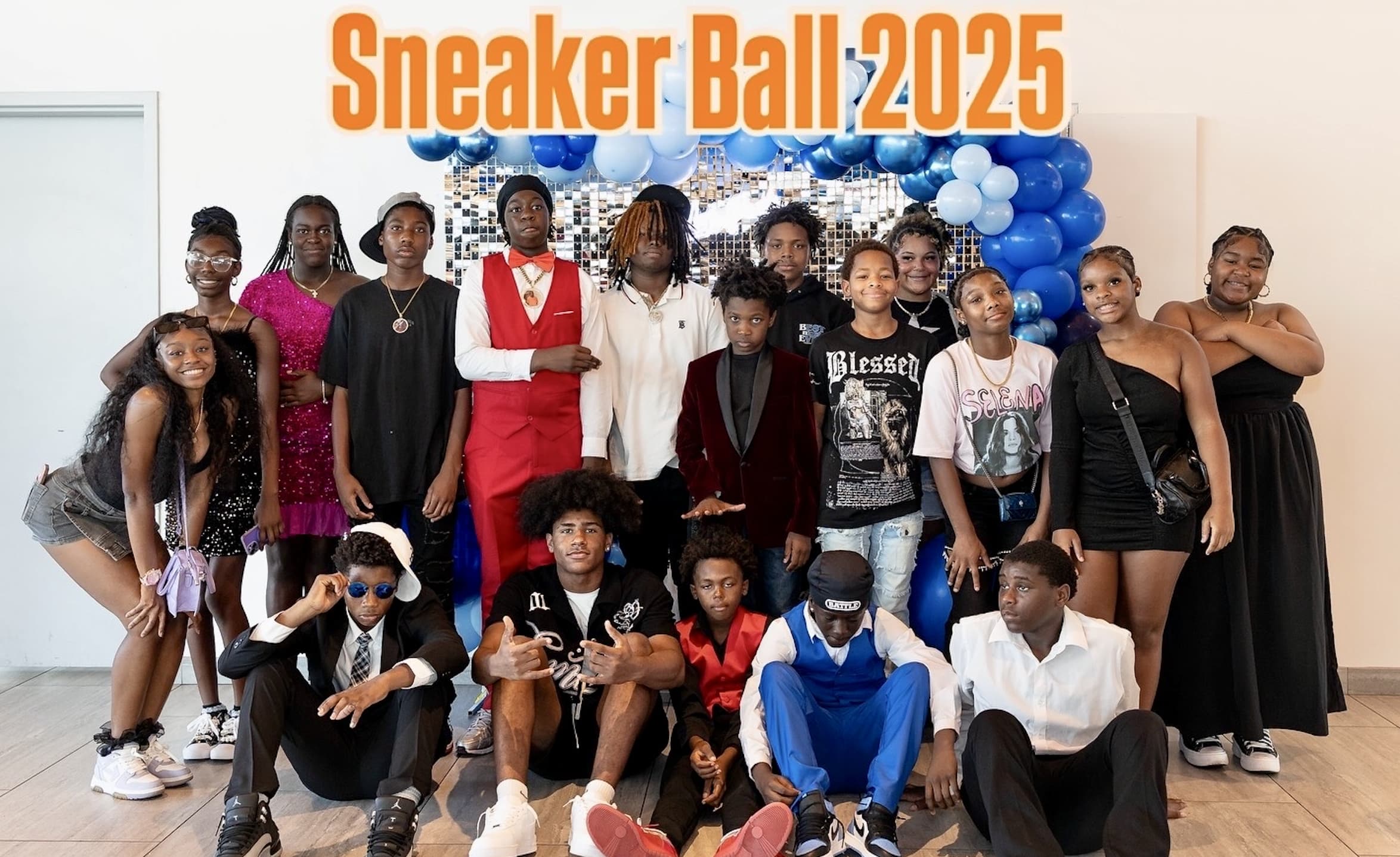 18 teens pose for a photo in front of Sneaker Ball 2025 background
