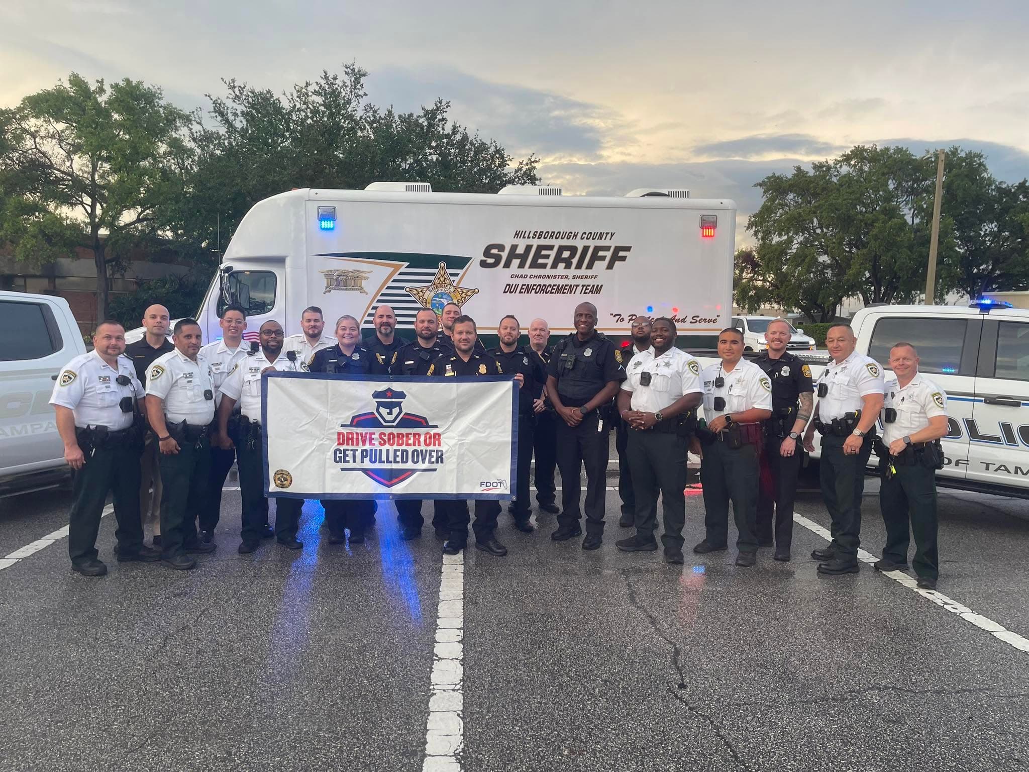 Police officers holding a sign that says drive sober or get pulled over