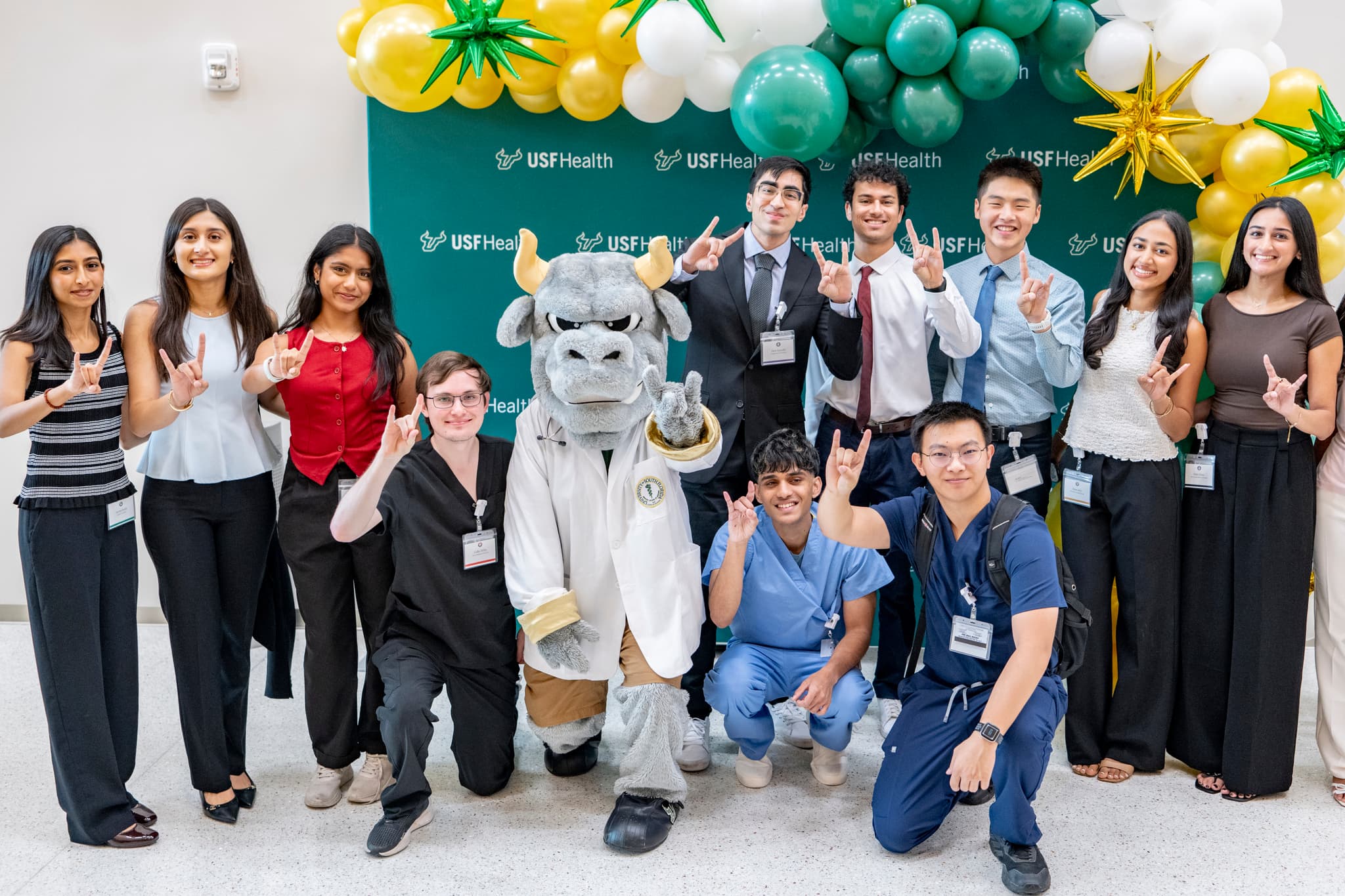 11 students and a bullmascot pose for a photo