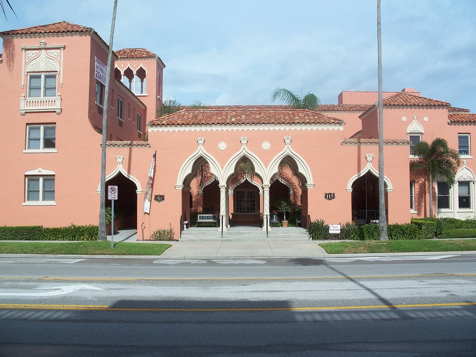 A pink Mediterranean Revival building with arched entryways and a tile roof on Davis Islands