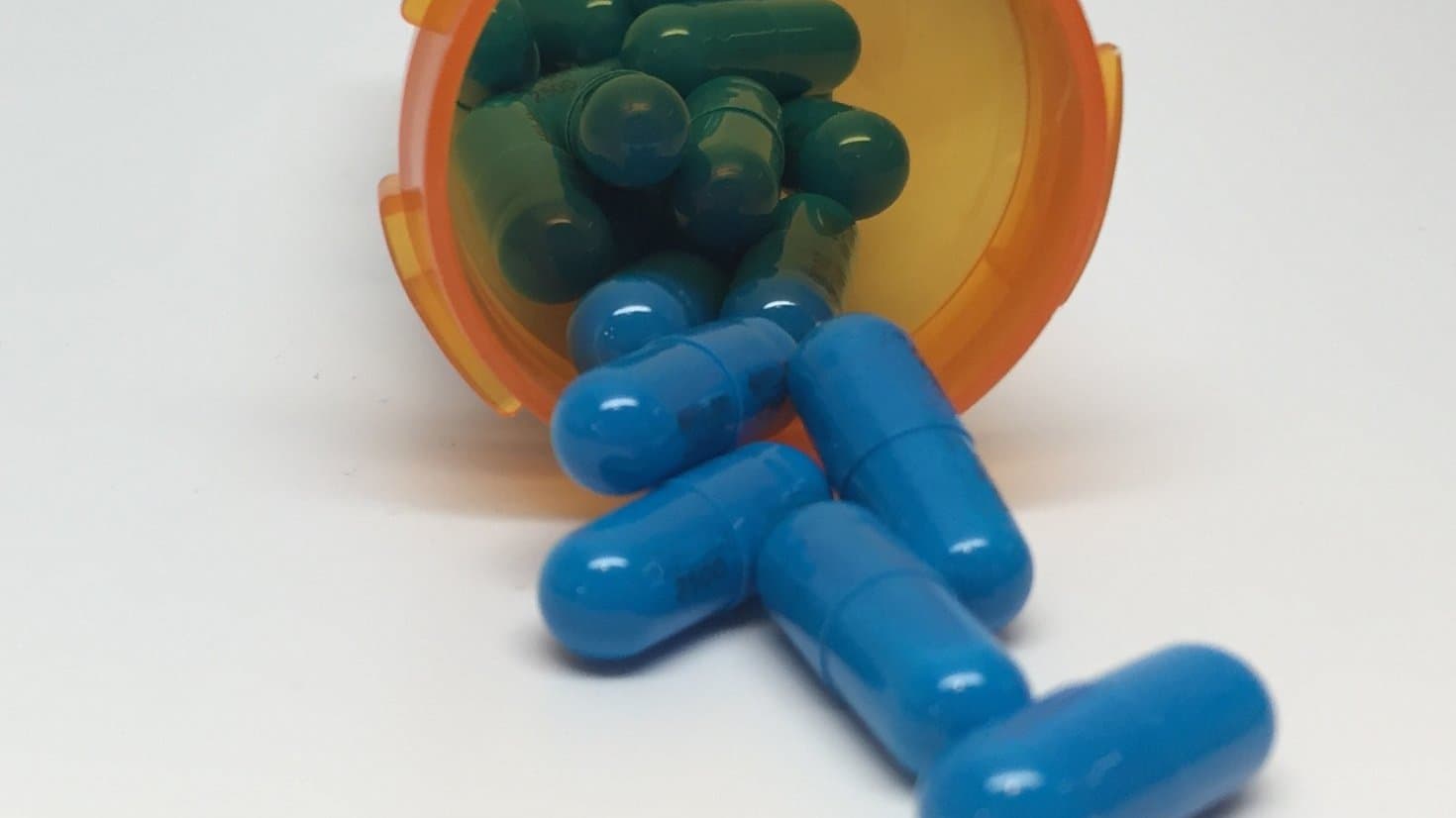 Capsules spilling out of an amber prescription bottle